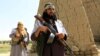FILE: Taliban fighters walk as they celebrate ceasefire in Ghanikhel district of the eastern Nangarhar Province in June.