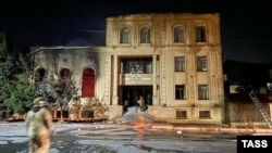 Сотрудники МЧС около поврежденной пожаром синагоги. Огонь начался во время нападения в июне 2024 года