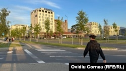 Un tânăr traversează strada în cartierul dezvoltat pe locul fostei platforme industriale Tractorul, la Brașov.