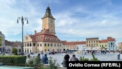 Turiști în Piața Sfatului, în centrul istoric al Brașovului.