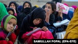 د کابل په څنډه کې د يو ګرځنډه ښوونځي زده کوونکي درس وايي ـ انځور له ارشيفه