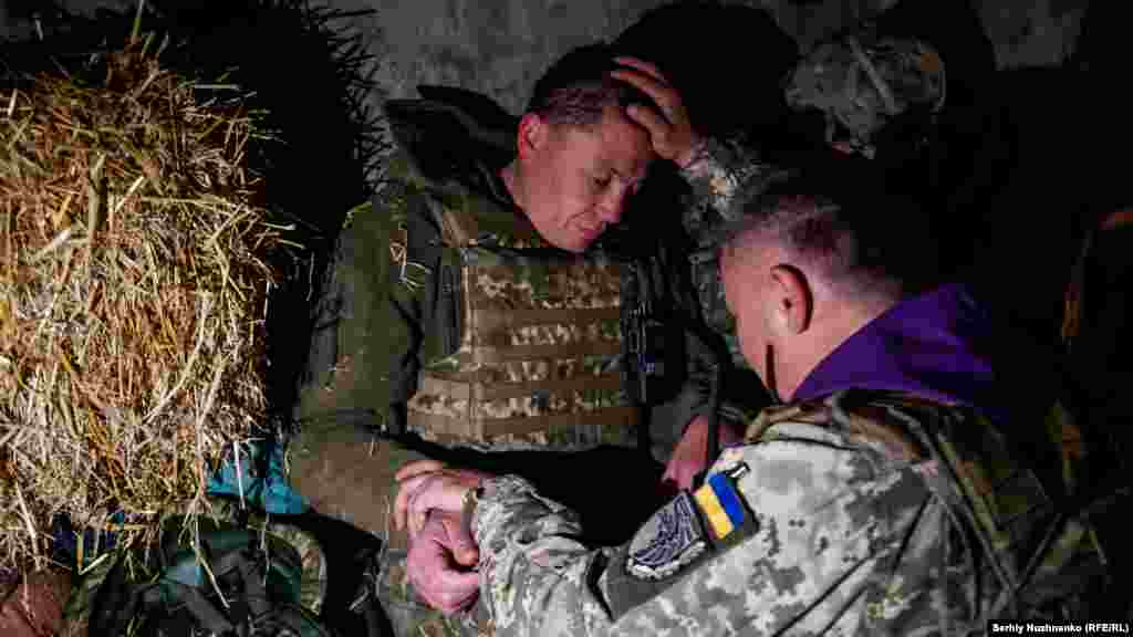 Александр, военный священник, благословляет украинского солдата. Харьковская область, 24 апреля 2022 года.
