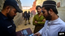 یو پاکستانی پولیس د افغان وګړي اسناد ګوري ـ پخوانی انځور.