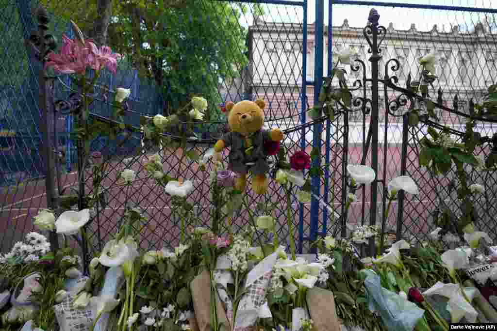 Цветы и игрушки возлагают жертвам возле школы Владислава Рыбникара в Белграде, Сербия, 4 мая 2023 года. 13-летний подросток открыл стрельбу в своей школе в столице Сербии. До прихода полиции он успел убить нескольких учеников и охранника. Несколько детей и учитель также были госпитализированы. (AP Photo/Darko Vojinovic)