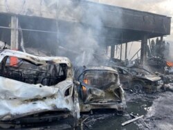 Сгоревшие автомобили у одного из зданий, пострадавших в результате обстрела центра Винницы