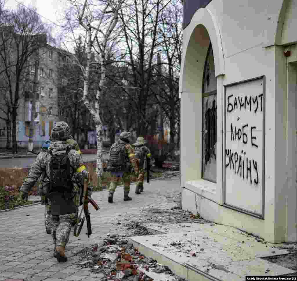 Украинские солдаты проходят мимо надписи «Бахмут любит Украину», 18 декабря. И Россия, и Украина в настоящее время бросают людей и технику в бой за Бахмут, город в Донбассе, который имеет относительно небольшое военное значение, но стал местом ожесточенных сражений
