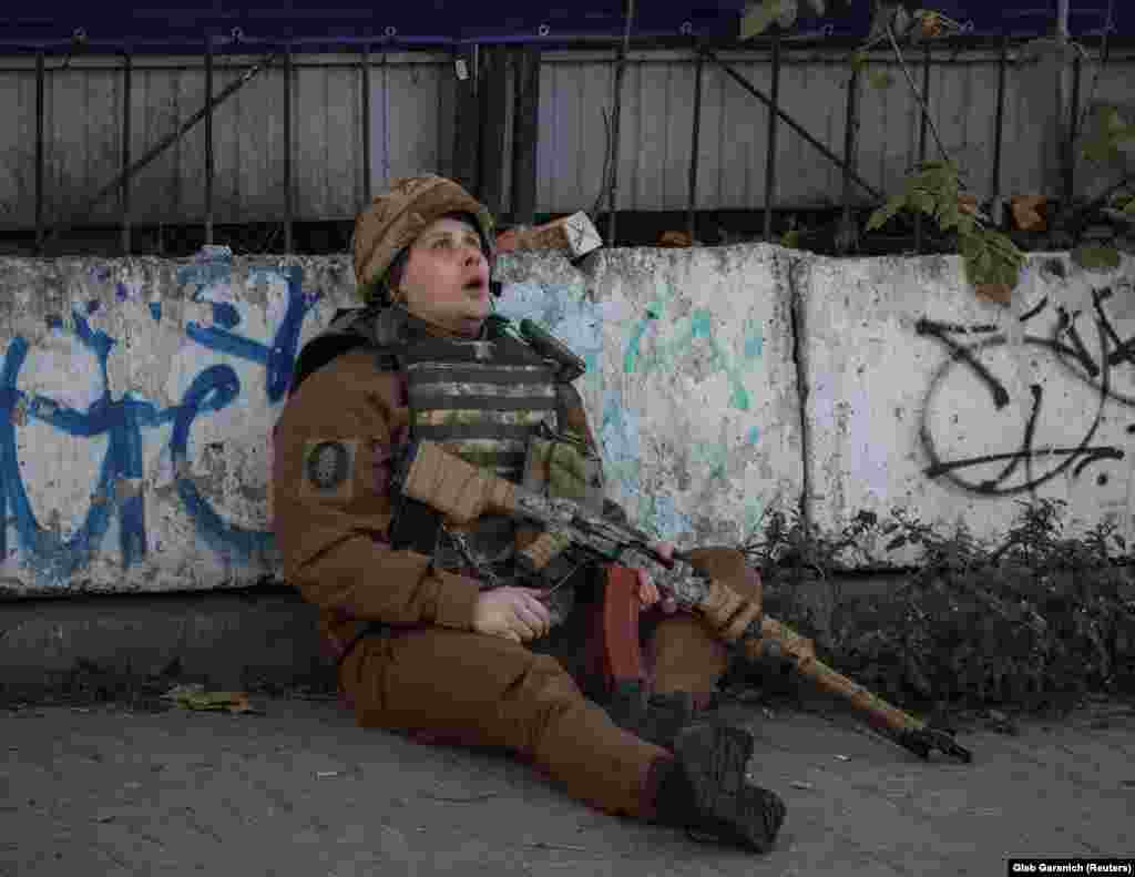 Военнослужащий смотрит в небо на фоне воющих сирен, которые сообщают о воздушной тревоге 