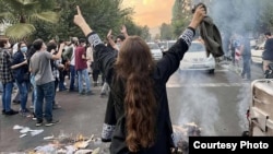 په تهران کې یوې ښځې د مظاهرې پر مهال حجاب لیرې کړی دی - د سېپټېمبر ۲۷مې انځور.