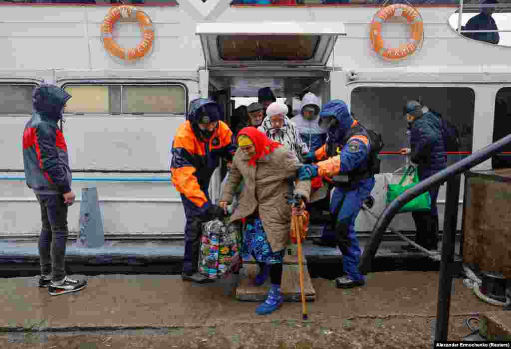 Пожилая женщина сходит с лодки в Олешках во время эвакуации из Херсона 23 октября. Накануне российские власти в Херсоне неоднократно призывали мирных жителей покинуть портовый город на юге Украины, призывая жителей «позаботиться о безопасность их семьи и друзей».
