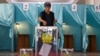 A woman casts her vote in the referendum at a polling station in Almaty on June 5.