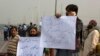 Supporters of a Pakistani religious group protest holding placards read "hang blasphemous Asia," as they blocked the main road to Islamabad on October 31.
