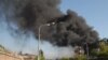 Armenia -- Onlookers watch as black smoke billows from the Nairit chemical plant in Yerevan hit by an explosion on 14May2009