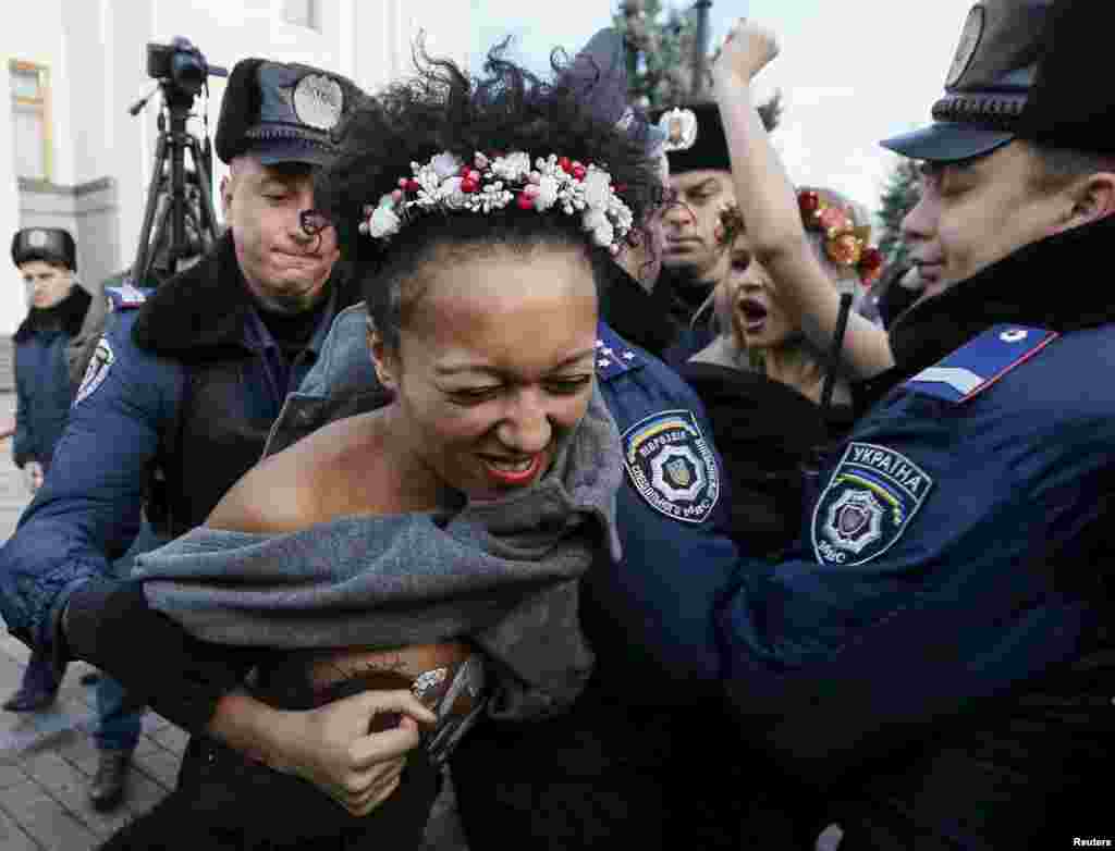 Киевалда полициялъ ккурай Femen къукъаялъул гIахьалчIужу. Гьаб нухалда гьел рахъун рукIана гьомофобиялде данде протест лъазабизе. 12Ноя2015 (Reuters/Gleb Garanich)