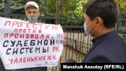 Активист Юрий Маленьких с плакатом на одиночной акции у специализированного межрайонного административного суда Алматы. 15 мая 2020 года.