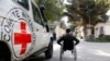 FILE: An Afghan handicapped man passes by a logo of ICRC in the pediatric center of the International Committee of the Red Cross (ICRC) in Kabul on October 10.