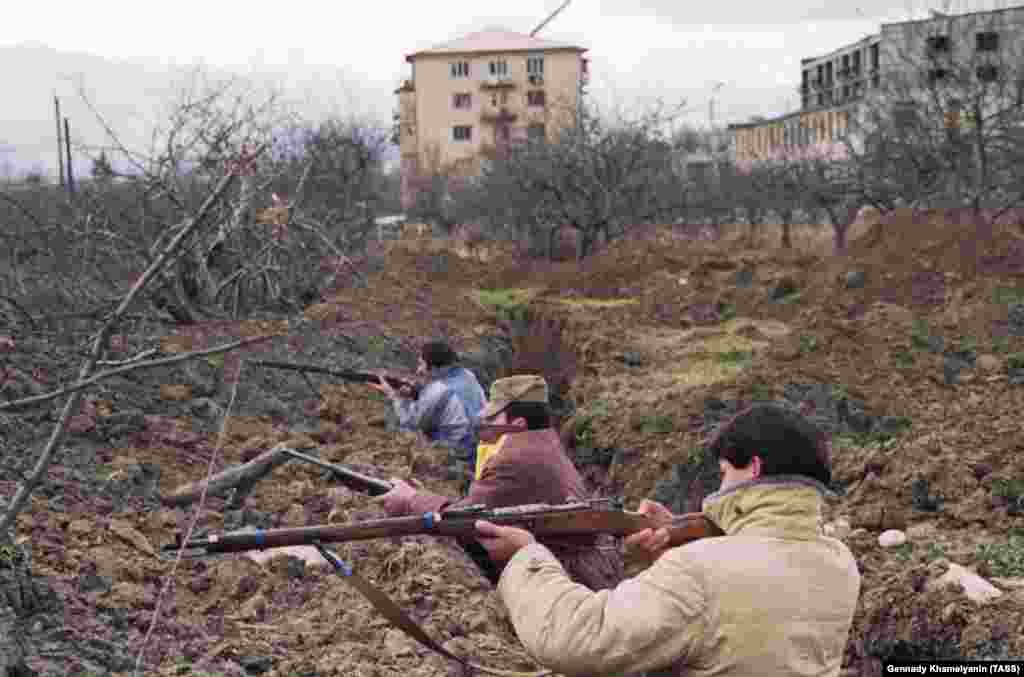 Осетини в окопах на околиці Цхінвалі. Чоловіки використовують застарілі російські гвинтівки Мосіна-Нагана, вперше випущені в 1890-х роках. Протягом 1991 року «клаптикова ковдра» грузинських і осетинських селищ, з якої складається Південна Осетія, роздиралася міжетнічними вбивствами і залякуваннями