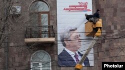 Armenia - Workers put up an election billboard of President Serzh Sarkisian in Yerevan, 21Jan2013.