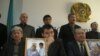 Opposition members with photos of Sarsenbaev at a February news conference