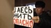 Житель села Березовка на встрече с заместителем министра энергетики Казахстана Узакбаем Карабалиным держит плакат с надписью: "Здесь жить опасно". Западно-Казахстанская область, 20 января 2015 года.