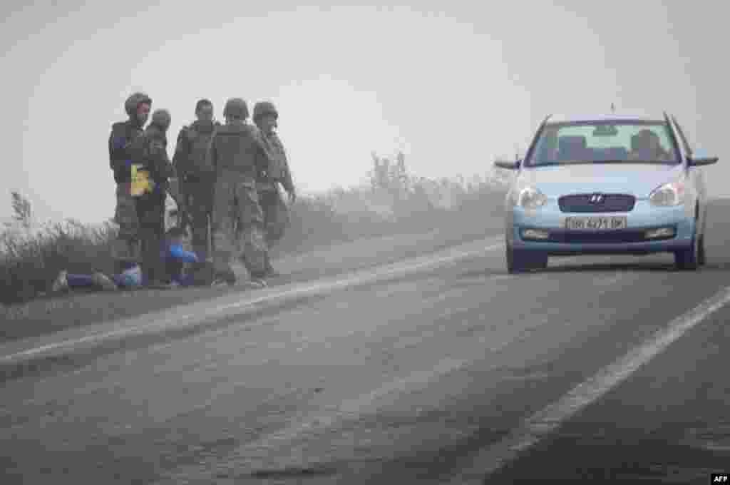 Українські військовослужбовці заарештувують підозрілого чоловіка на КПП перед Дебальцево в Донецькій області, 23 вересня 2014 року