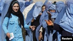 FILE: Afghan widows wait to receive monthly rations from the World Food Program in Kabul.