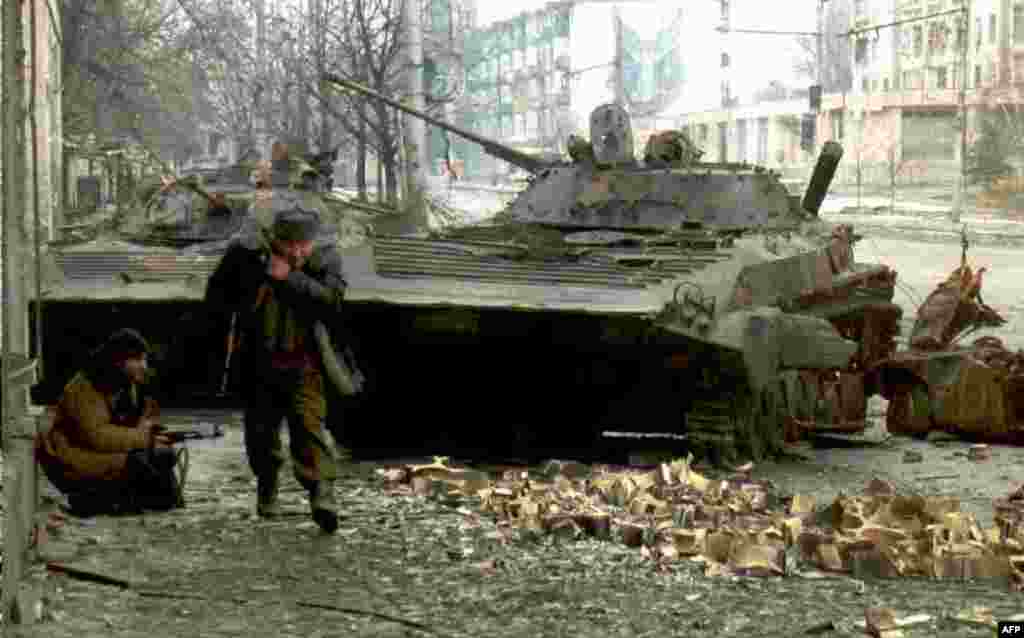 В первые дни войны лишь одна колонна русской техники потеряла 105 танков и бронетранспортеров из 120 На фото – чеченские бойцы возле разрушенных русских танков, 10 января 1995 года