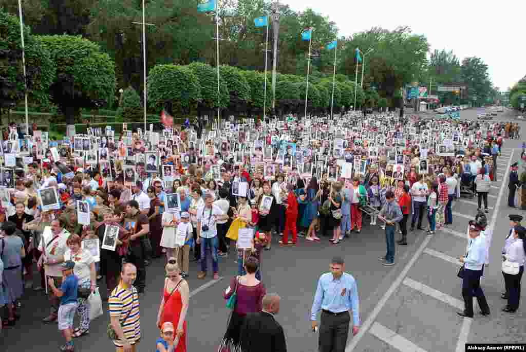В Алматы акция «Бессмертный полк» проводится второй раз. Она является частью «Марша ветеранов», проводимого в восьмой раз. В прошлом году в ней приняли участие только десятки человек. В этом году благодаря информированию в социальных сетях акция была масштабной. Трудно было найти точку, с которой бы можно было сфотографировать колонну во всю ее длину.