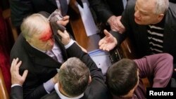 Ukrainian pro-government lawmaker Vladimir Malyshev is hurt during scuffles in parliament over an antiprotest law and other controversial legislation, which was passed on January 16.