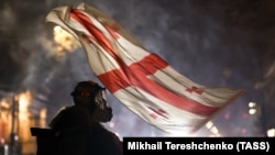 A protester waves a Georgian flag during protests in Tbilisi on December 7, 2024. 