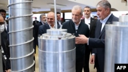 Iranian President Masud Pezeshkian (second right) and Atomic Energy Organisation of Iran chief Mohammad Eslami (right) are pictured at an event for Iran's Nuclear Technology Day in Tehran on April 9.
