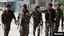 Szíriában egyes milíciákat azzal vádolnak, hogy a harcok lecsengése ellenére gyerekeket toboroznak soraikba. A képen a kurd Népi Védelmi Egység (YPG) fegyveresei Kamisliben 2016 áprilisában