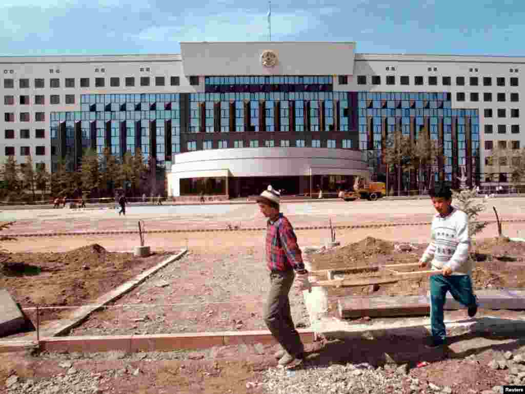 Рабочие во время возведения нового президентского дворца в мае 1998 года. С 1992 по 1998 год Астана зовется Акмолой. Перенос туда столицы обсуждается на государственном уровне с 1994 года. В 1997 году Назарбаев принимает окончательное решение. Летом издается президентский указ о переименовании в Астану, что в переводе с казахского языка означает "столица". В тот же период город в новом статусе был презентован на международном уровне. 