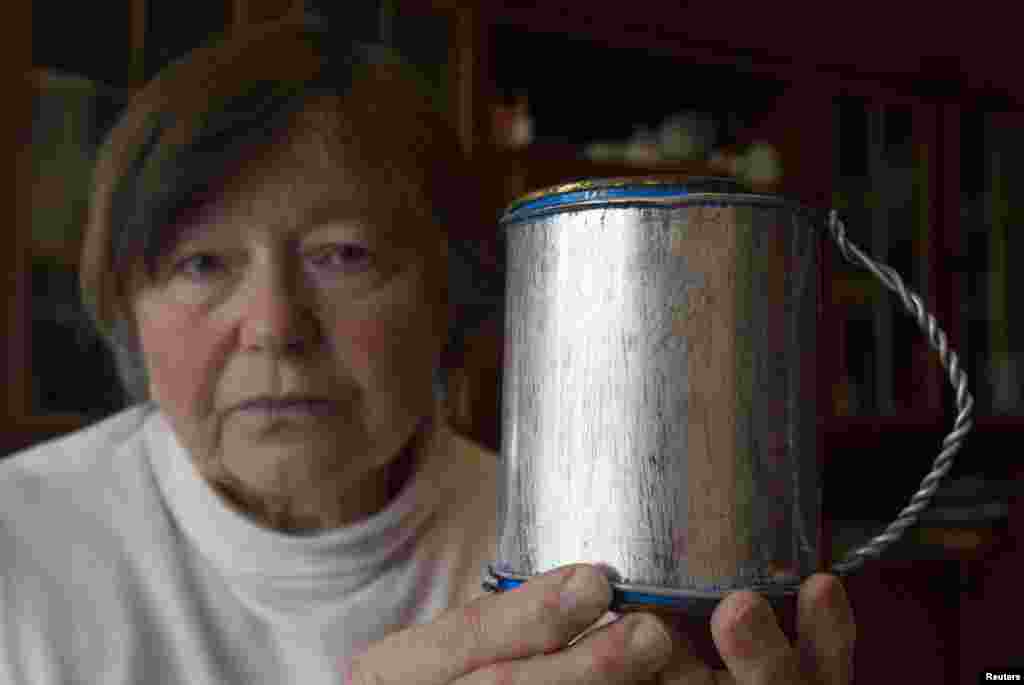 76-летняя Зинаида Тарасевич с самодельной кружкой, которую ей когда-то подарила мать. Этой кружкой и другой примитивной посудой родители Зинаиды пользовались в годы заключения в сталинских лагеря. В семье Зинаиды были репрессированы более 20 родственников. Выжить и вернуться в Минск после смерти Сталина удалось только ее родителям.