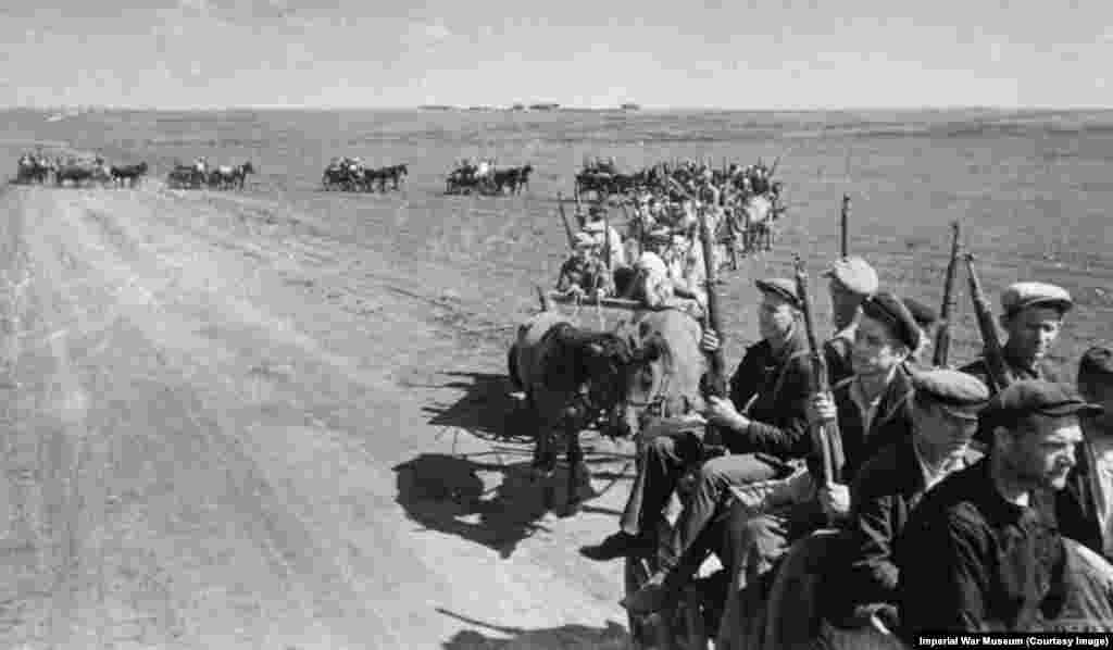 Советские граждане направляются на передовую, вооруженные винтовками Мосина — Нагана царских времен. 