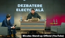 Фота з дэбатаў, на якія не прыйшоў Джорджэ Сім’ён, і ягоны супернік Нікушор Дан сядзіць насупраць пустога крэсла