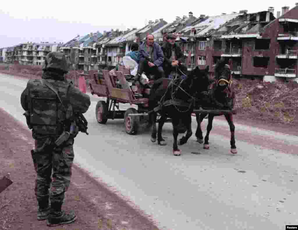 Konjska zaprega sa ličnim stvarima bosanskih Srba prolazi pored vojnika francuskog IFOR-a na izlasku iz Sarajeva na putu prema teritoriji Republike Srpske, 30. januar 1996. 