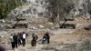 Un grup de palestinieni se evacuează din nordul Fâșiei Gaza, cu tancuri israeliene în urma lor, pe drumul Salah al-Din, pe 24 noiembrie 2023. Agențiile umanitare trag un nou semnal de alarmă cu privire la situația umanitară.