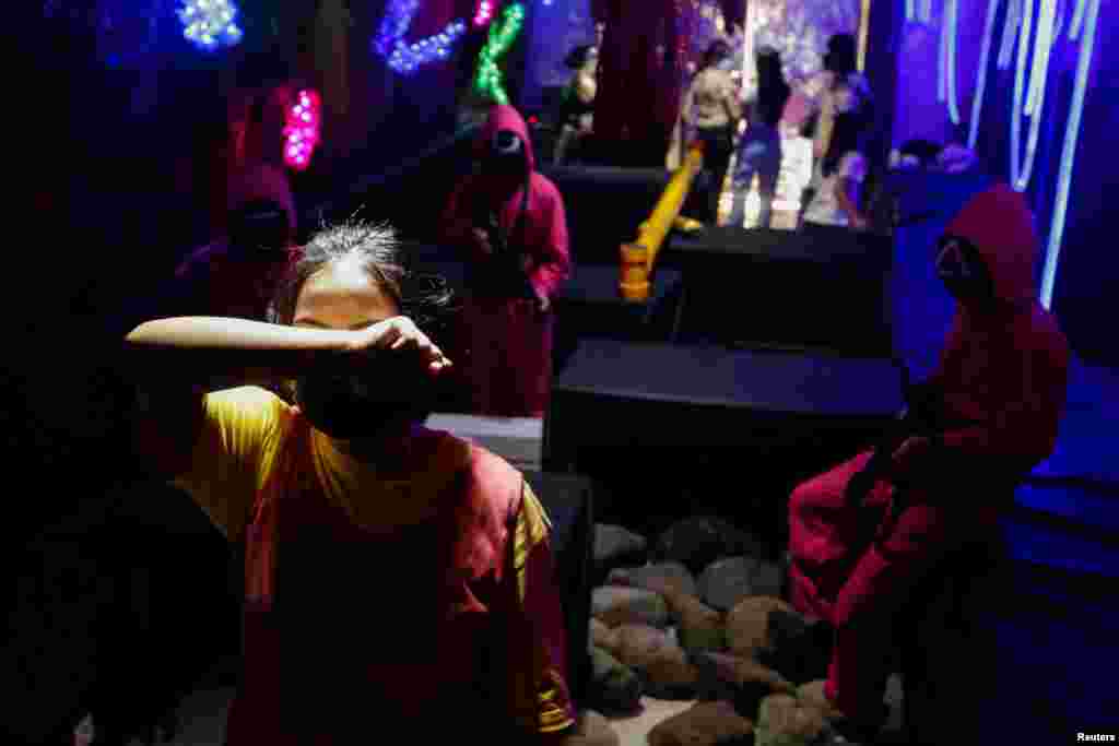 A customer plays 'Red Light, Green Light' game from the Netflix show 'Squid Game' at Strawberry Cafe in Jakarta, Indonesia, October 15, 2021