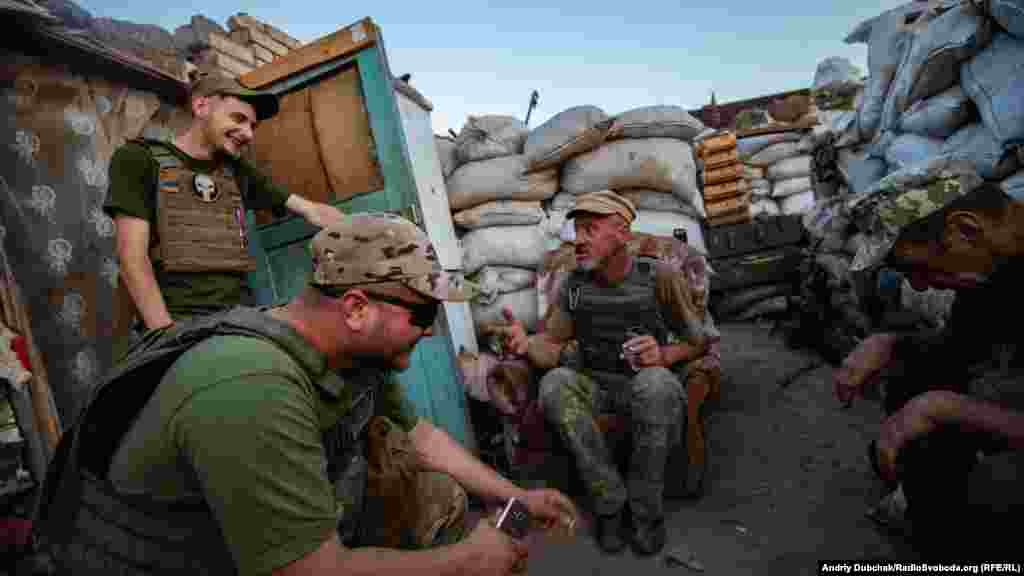 Передовые позиции украинских военных. В перерывах между дежурствами и работой по хозяйству, военные проводят время в разговорах, интернете, читают или спят. На фото – солдат Василий рассказывает веселую историю из своей жизни