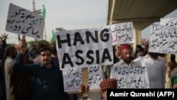 Supporters of Tehreek-e Labaik Pakistan, a hardline religious political party hold placards as they march during a protest in Rawalpindi on October 12.