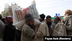 پېښور کې یو تن د اوړو بوجۍ پر اوږو. تصویر له ارشیفه