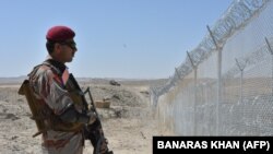 A Pakistani Army soldier stands guard along a border fence at the Afghan border near the Punjpai area of Quetta in Balochistan Province.