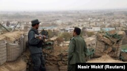 FILE: Afghan police officers keep watch at their forward base on the outskirts of Kunduz Province.