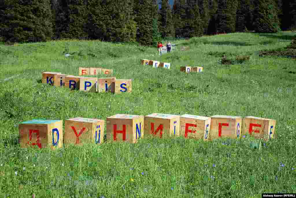 Асель Кадырханова создала инсталляцию &laquo;Другие буквы&raquo;. Это расположенные на обширной площади склона кубы из дерева. На них &mdash; буквы трех алфавитов (арабский, латинский и кириллический), в которых представлен казахский язык. Из букв создается фраза &laquo;И ты кирпич в мироздании&raquo; из произведения Абая. С одной стороны, это создает смешение кодов, затрудняя прочтение. С другой &mdash; объединяет прошлое, настоящее и будущее казахского алфавита в одной конструкции, считает автор.