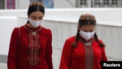 Жени със защитни маски, заснети на улицата в Ашхабад.