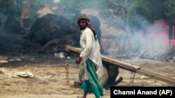 An Indian man walks near a residential area that was gutted from firing allegedly from the Pakistan side of the border in Jora farm village, in Ranbir Singh Pura district of Jammu and Kashmir in May.
