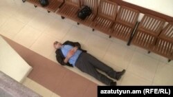 Armenia - Activist Vardges Gaspari lies down during his trial in Yerevan, 29Feb2016