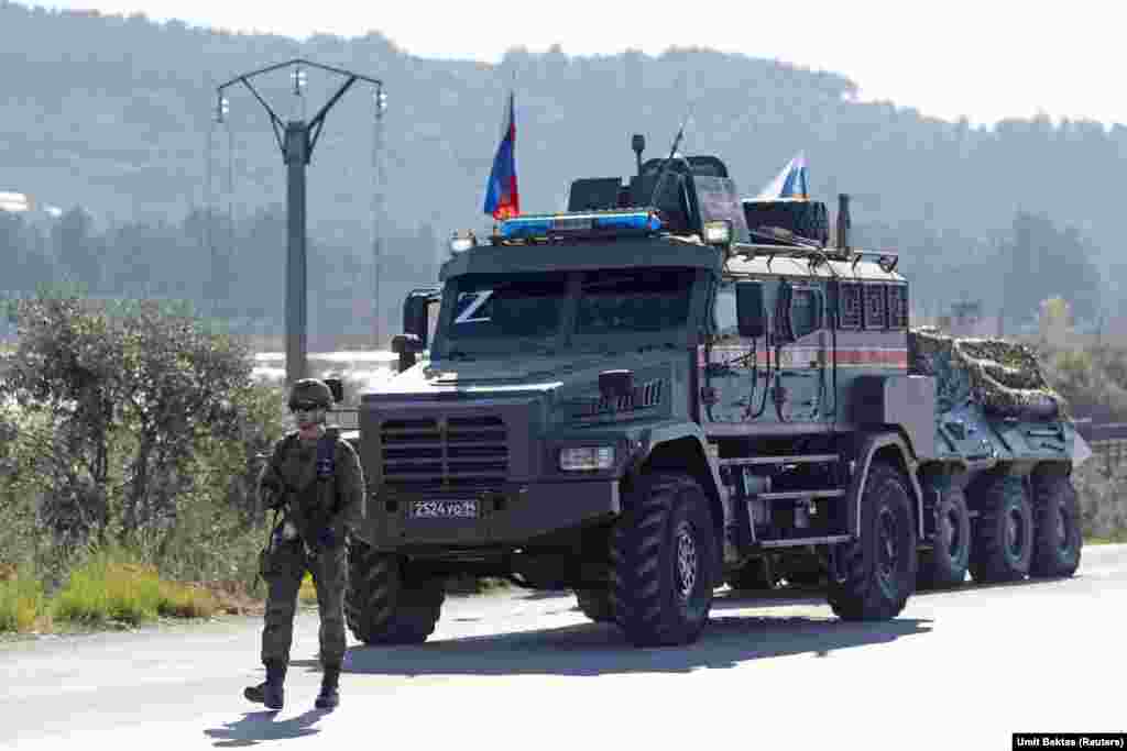 Un soldat rus păzește un convoi care s-a stricat pe un drum, în apropierea bazei aeriene Hmeimim. „O mulțime de convoaie sosesc și pleacă într-una. Pe teritoriul bazei, unii par să aștepte ceva, pentru că poți vedea multe corturi noi”, spune Bektas. 