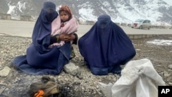 په کابل کې دوو ښځو د سړک پر غاړه له يو ماشوم سره د ځان تودولو لپاره اور بل کړی دی ـ انځور له ارشيفه