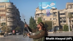 Syria - A Syrian opposition fighter shoots in the air in downtown Aleppo, November 30, 2024.